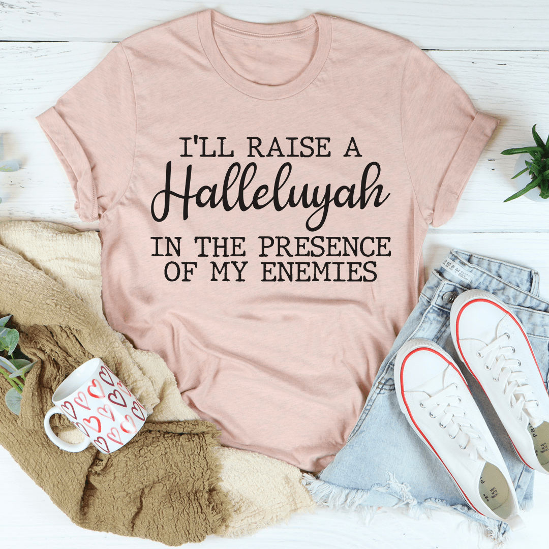 A black t-shirt featuring the phrase 'I'll Raise A Halleluyah In The Presence Of My Enemies' printed in white, showcasing a stylish and comfortable design.